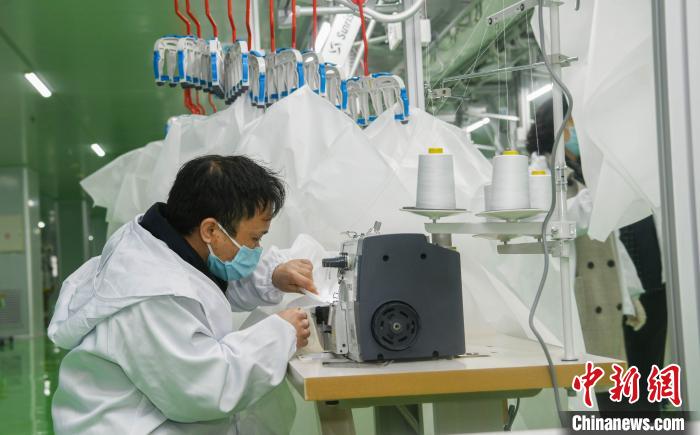 工人生產(chǎn)防護服，保障抗疫物資供應(yīng)。廣安市委宣傳部供圖