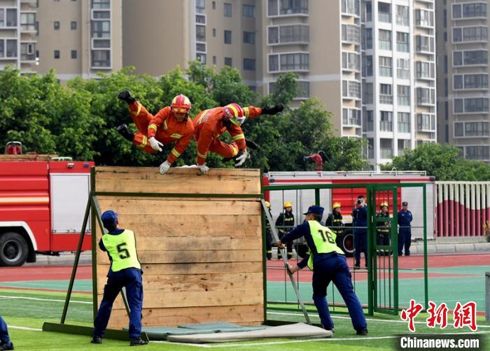 新消防員進(jìn)行消防障礙接力操展示?！⒅铱?攝