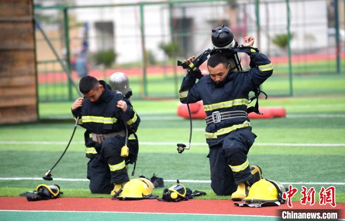 新消防員進(jìn)行穿戴空呼器展示?！⒅铱?攝