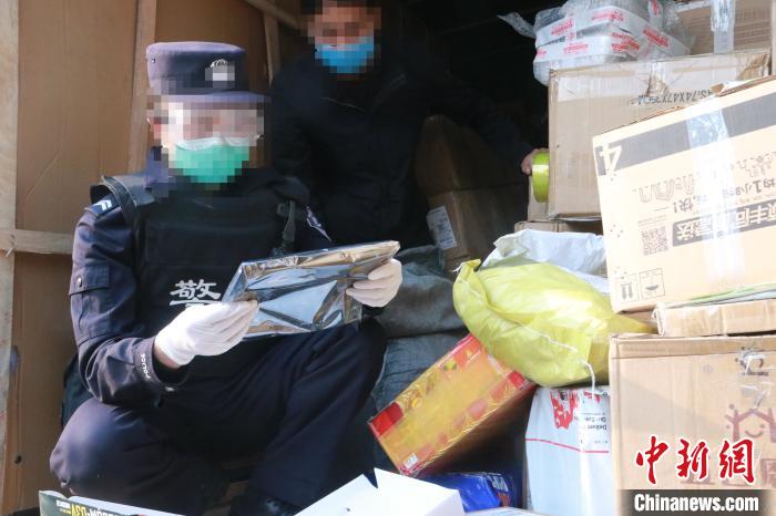 圖為勐康邊檢站民警在對(duì)快遞運(yùn)輸車輛進(jìn)行例行檢查。　楊添 攝