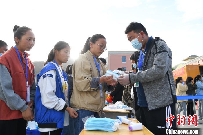 7月7日，考生在拉薩三高考點(diǎn)外領(lǐng)取口罩?！『闻罾?攝