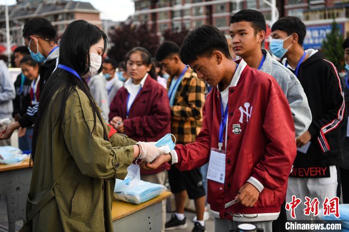 7月7日，考生在拉薩三高考點(diǎn)外測(cè)量體溫。　何蓬磊 攝